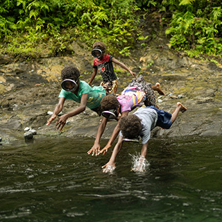 Abkühlung an heißen Tagen: Kinder auf Vanuatu springen in einen Fluss. © Conor Ashleigh / Save the Children Kinder springen in einen Fluss