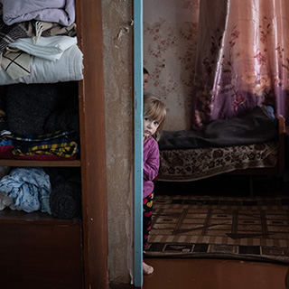 Kinder in der Ukraine haben Angst vor Luftangriffen. Save the Children steht ihnen zur Seite. © Anastasia Vlasova Kinder schauen ängstlich aus einer Tür