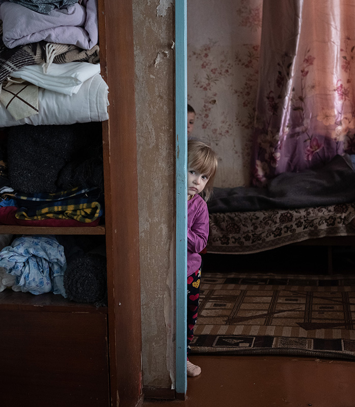 Kinder in der Ukraine haben Angst vor Luftangriffen. Save the Children steht ihnen zur Seite. © Anastasia Vlasova Kinder schauen ängstlich aus einer Tür